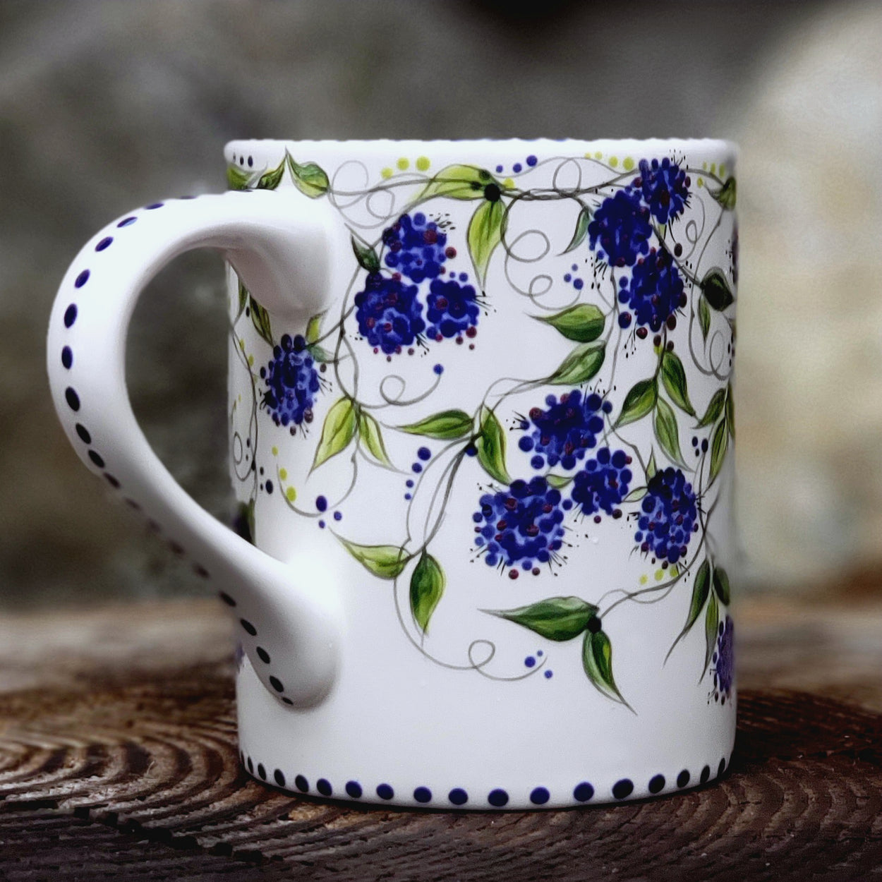 Hand painted Blackberries and vines cover this entire mug. Dark blue with hints of purple berries and beautiful dark green vines and leaves make this one very special. 16 ox kiln fired ceramic mug