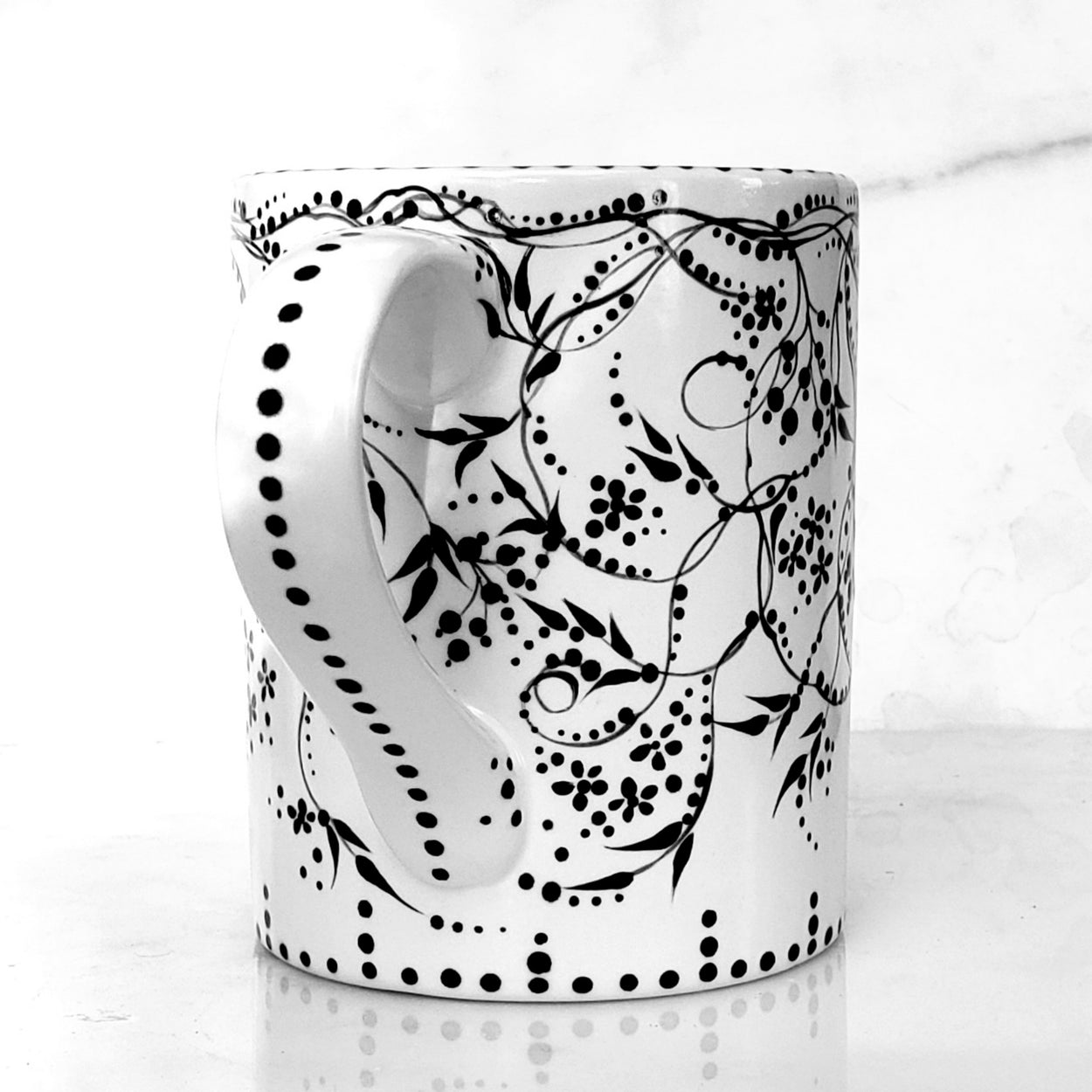 Hand painted black and white mug with trailing vines and berries and tiny flowers. Lovely satin glaze. 16 oz kiln fired ceramic mug