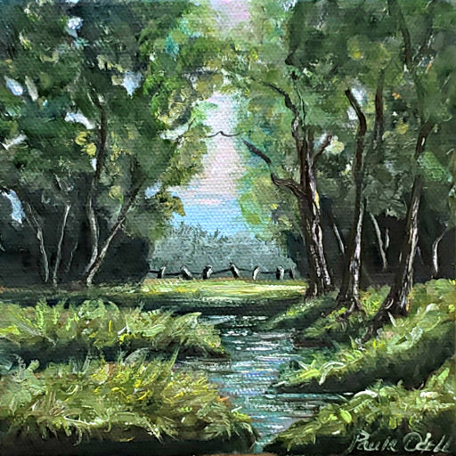 Spring day with beautiful little creek and green grass, blue sky and pasture in distance with fence and blue sky