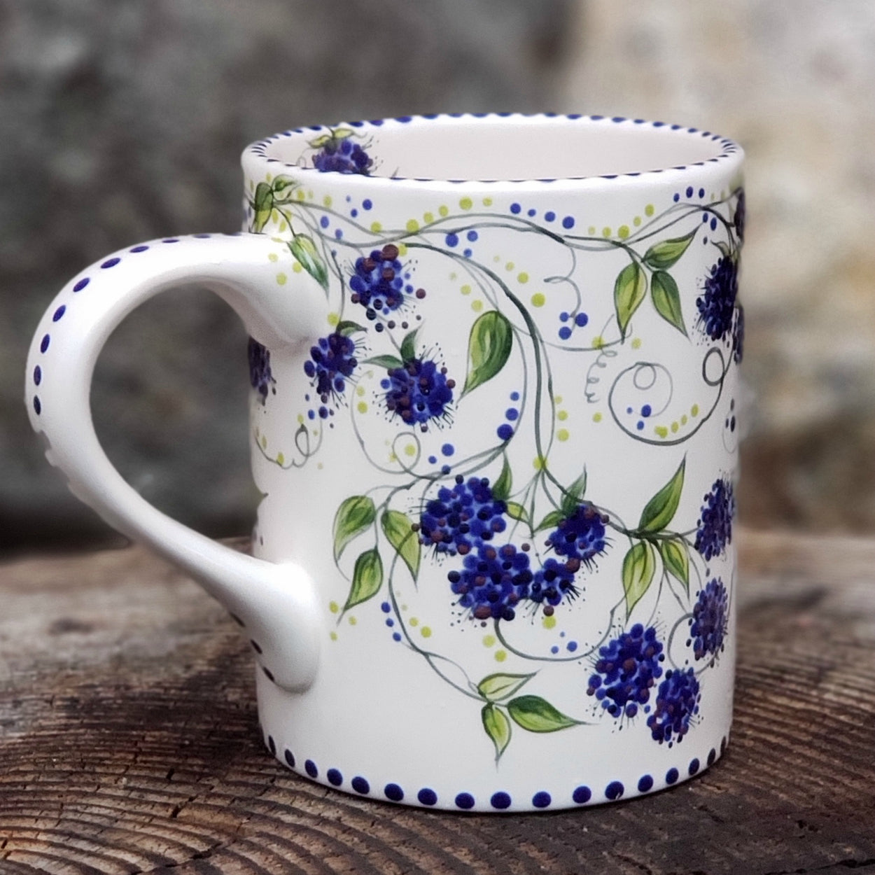 Hand painted Blackberries and vines cover this entire mug. Dark blue with hints of purple berries and beautiful dark green vines and leaves make this one very special. 16 ox kiln fired ceramic mug