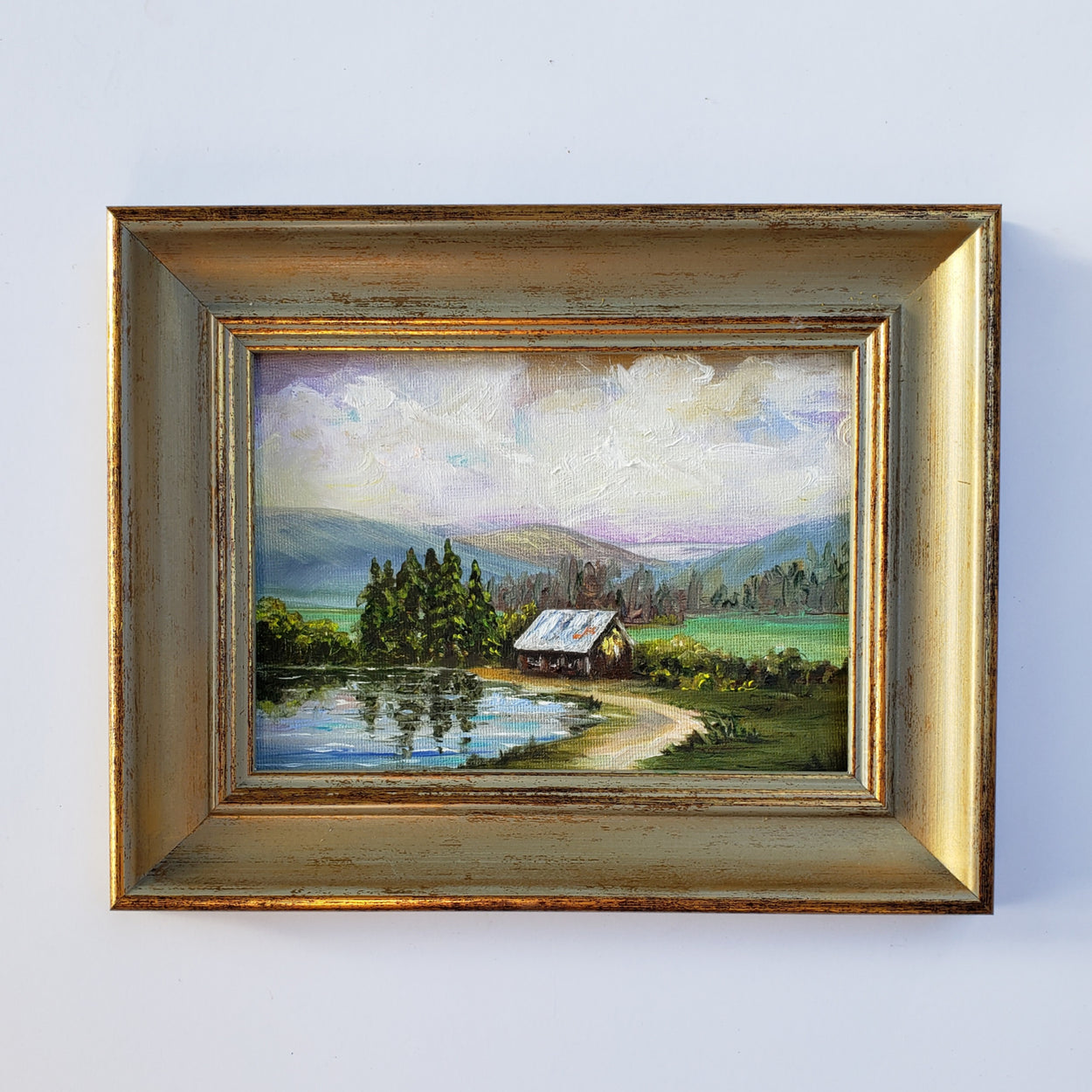 Original oil painting of the pond by the barn... puffy clouds and mountains in a peaceful setting.