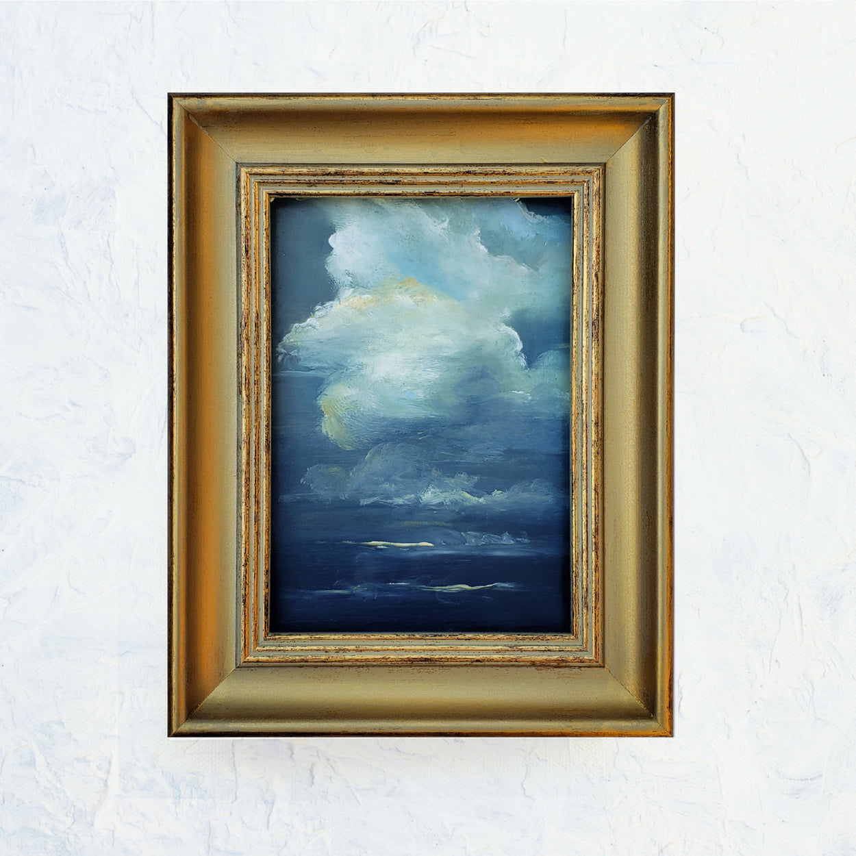 5x7 oil on oil paper... dramatic dark blue gray sky with beautiful puffy white and golden clouds. Framed in gold vintage style frame