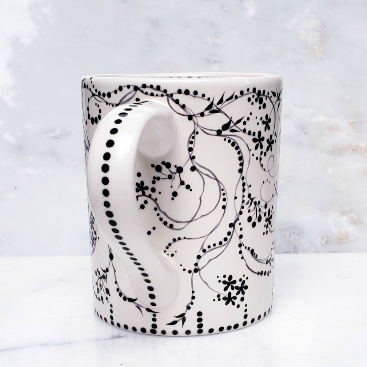 Beautiful black and white mug with vintage inspired design.. tiny flowers and vines encircle the mug with the sweetest polka dots as acents. 16 oz ceramic kiln fired mug