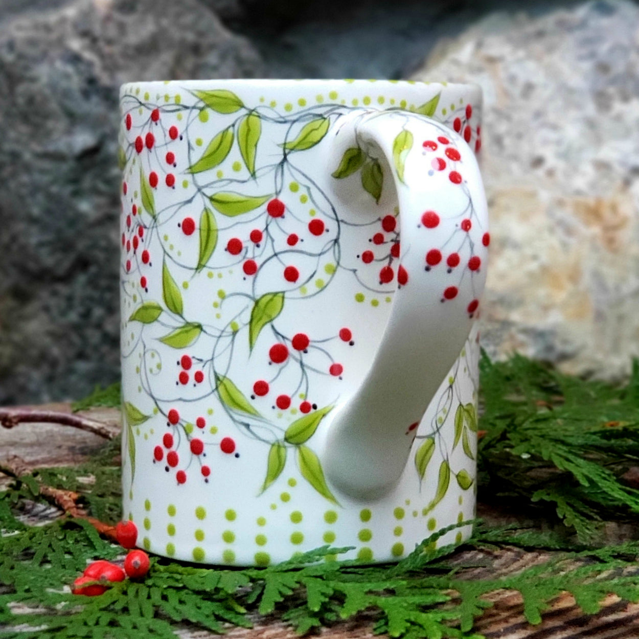 hand painted big mug with bright red berries and trailing vines and lime green leaves. It even has darling berries falling to the inside. 16 oz kiln fired ceramic mug