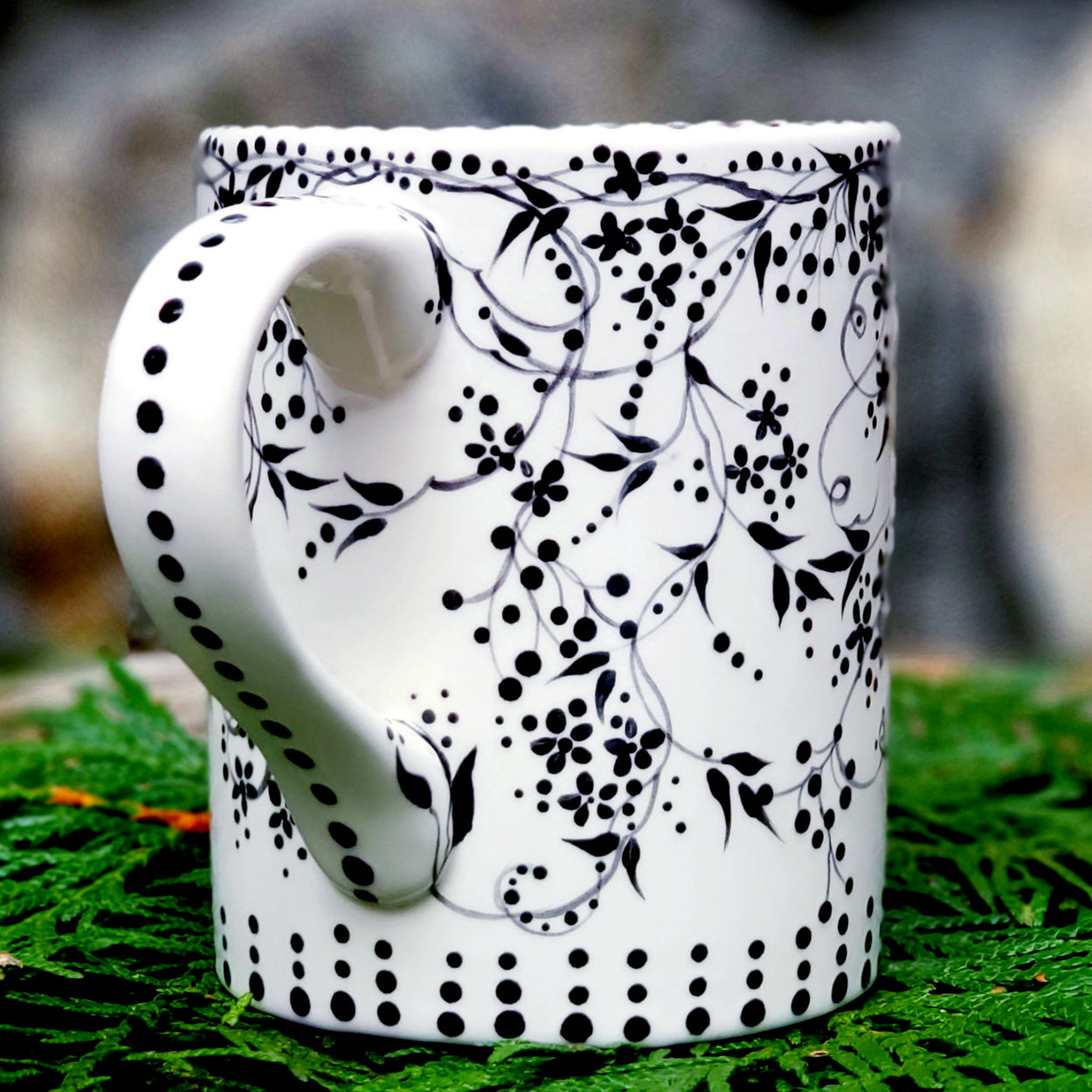 Hand painted black and white mug with trailing vines and berries and tiny flowers. Lovely satin glaze. 16 oz kiln fired ceramic mug